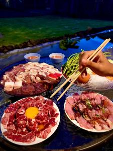 una mesa cubierta con platos de comida con palillos chinos en บ้านพักตากอากาศ ยินดีต้อนรับสัตว์เลี้ยง, 