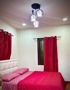 1 dormitorio con cama roja y ventana en บ้านพักตากอากาศ ยินดีต้อนรับสัตว์เลี้ยง 