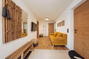 ein Wohnzimmer mit einem gelben Sofa und einer Holztür in der Unterkunft Ferienwohnung Schiebakopf in Vandans
