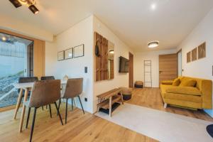 ein Wohnzimmer mit einem gelben Sofa und einem Tisch in der Unterkunft Ferienwohnung Schiebakopf in Vandans