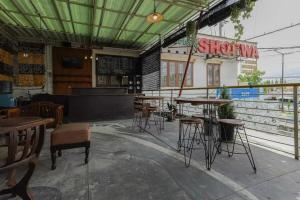 a restaurant with tables and stools in a room at OYO 91292 Pondok Inap Shofwa 1 in Sidoarjo