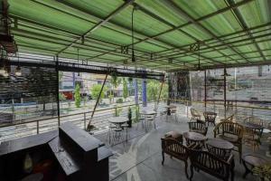 a restaurant with tables and chairs and a green ceiling at OYO 91292 Pondok Inap Shofwa 1 in Sidoarjo