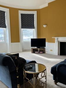 a living room with a couch and a tv at The Apartment Mount Galpine in Dartmouth