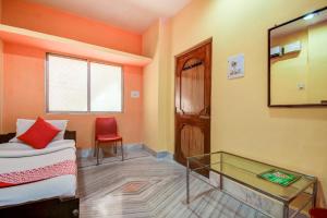 Cette chambre comprend un canapé, une table et un miroir. dans l'établissement Super OYO Hotel Priyal Amrit Sagar, à Rourkela