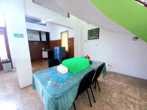 una habitación con una mesa con un artículo verde. en Homestay Jogja Samirono Dekat UNY by Simply Homy en Yogyakarta