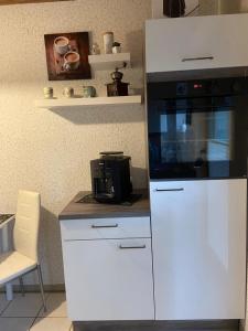 a kitchen with a white cabinet with a microwave at Gemütliche Ferienwohnung in Remscheid