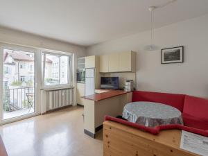 un soggiorno con un divano rosso e una cucina di Merano-biz a Merano