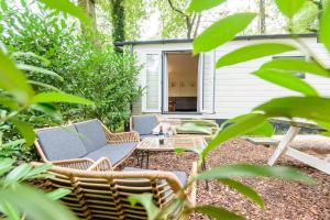a backyard with a patio furniture and a table at Veluwe Chalet aan het bos - Kids - Pool - Dog in Hoenderloo