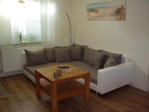 een woonkamer met een bank en een salontafel bij Ferienhaus in Dornumersiel 20-159 in Dornumersiel