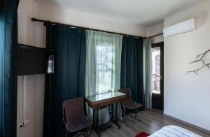 une chambre avec une table, des chaises et une fenêtre dans l'établissement Stagiates Guest House at Pelion, à Portariá