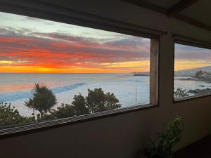 a view of the ocean from a window with a sunset at Le Cannelle in Saint-Pierre
