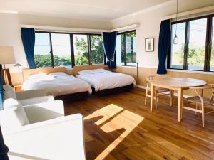 ArazatoにあるVILLA AZZURRA - Vacation STAY 63031vのベッド2台とテーブルが備わるホテルルームです。
