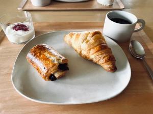 einen Teller mit zwei Croissants und einer Tasse Kaffee in der Unterkunft VILLA AZZURRA - Vacation STAY 63031v in Arazato