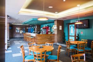 a restaurant with tables and chairs and a bar at Hotel Elegance in Šumperk
