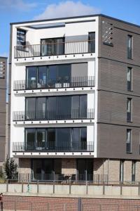 un edificio alto con balcones a un lado. en Allerinsel - Appartement am Celler Yachthafen, en Celle