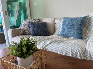 a couch with blue and white pillows in a living room at True Beachfront Oasis With Amazing Views Life in Luquillo