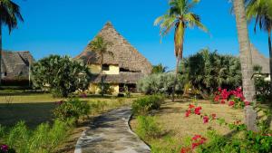 un complejo con palmeras y flores y un camino en Relaxing Beach Front Villa en Mambrui