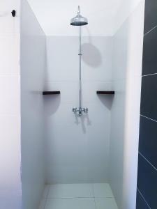 a white bathroom with a shower with a light at Relaxing Beach Front Villa in Mambrui