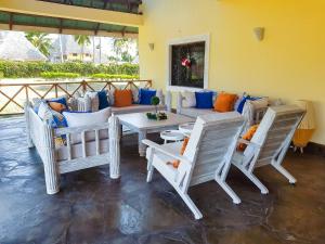 ein Wohnzimmer mit einem Sofa und Stühlen in der Unterkunft Relaxing Beach Front Villa in Mambrui