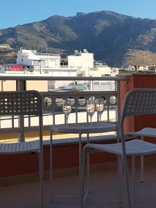 una mesa y sillas en un balcón con copas de vino en City center luxury studio en Karistos