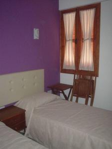 een slaapkamer met 2 bedden en een paarse muur bij Lasa Heights Hotel in Lasa