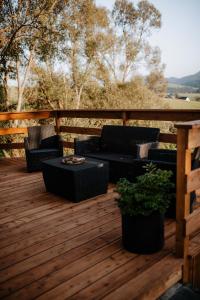 a wooden deck with four chairs and a table at Cichosza domki w Pieninach in Grywałd