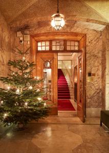 a christmas tree in a hallway with a staircase at Hotel Diplomat Stockholm in Stockholm