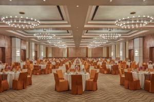 un salón de banquetes con mesas, sillas y lámparas de araña en Doubletree By Hilton Varanasi, en Varanasi