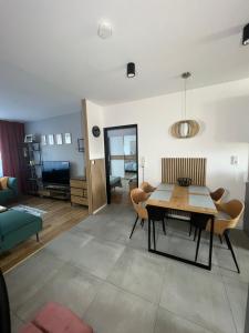 une salle à manger et un salon avec une table et des chaises dans l'établissement Apartmán pod Lesom Kežmarok, à Kežmarok