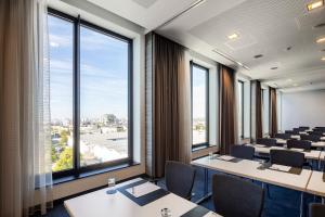 a conference room with tables and chairs and large windows at IntercityHotel Hamburg Dammtor-Messe in Hamburg