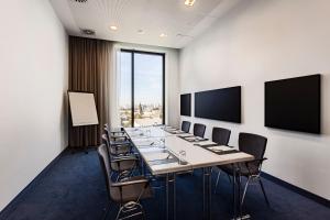 una sala de conferencias con una mesa larga y sillas en IntercityHotel Hamburg Dammtor-Messe en Hamburgo