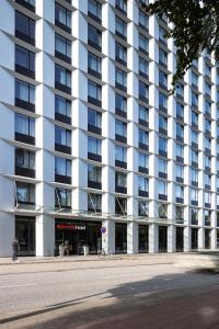 ein großes Apartmenthaus mit einer Straße davor in der Unterkunft IntercityHotel Hamburg Dammtor-Messe in Hamburg