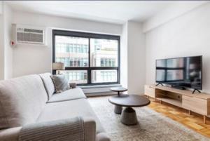 a living room with a couch and a flat screen tv at Comfortable 3 Bedroom Apartment in New York