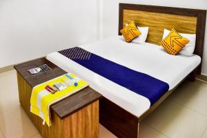 a bedroom with a bed with a wooden head board at SPOT ON City Tower Inn in Jāmul