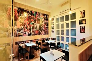 a restaurant with tables and chairs and posters on the wall at Townhouse Kachnar House Vikas Nagar in Hasanganj