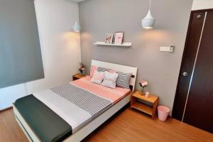 ein kleines Schlafzimmer mit einem Bett in einem Zimmer in der Unterkunft Pink Studio Serene Heights Condo One bedroom 2 beds & Sofa Bed in Miri
