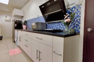a kitchen with a counter top with a microwave at Pink Studio Serene Heights Condo One bedroom 2 beds & Sofa Bed in Miri