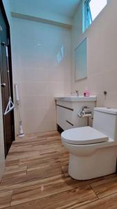 a bathroom with a white toilet and a sink at Pink Studio Serene Heights Condo One bedroom 2 beds & Sofa Bed in Miri