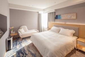 een hotelkamer met een bed en een stoel bij City Hotel Shanghai in Shanghai