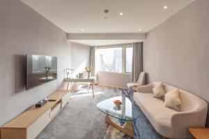 a living room with a couch and a table at City Hotel Shanghai in Shanghai