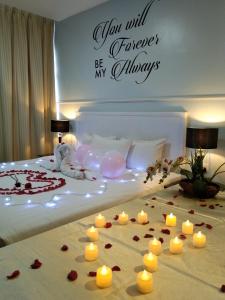 TY Hotel في كوالا ترغكانو: غرفة نوم مع شموع وورد على سرير
