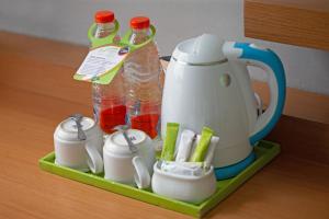 a tea kettle and bottles of water on a tray at Whiz Hotel Malioboro Yogyakarta in Yogyakarta