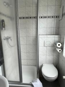 a small bathroom with a toilet and a shower at Brauhaus Hotel Ruetershoff in Castrop-Rauxel