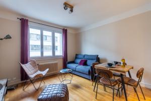een woonkamer met een bank en een tafel en stoelen bij La Marmotte: 2 persons, center and lake, 3* in Annecy