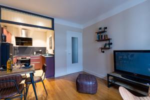een woonkamer met een televisie en een tafel met stoelen bij La Marmotte: 2 persons, center and lake, 3* in Annecy