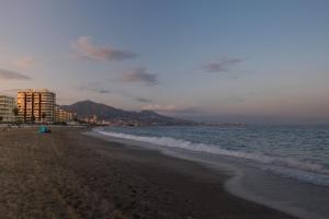 une plage avec l'océan et des bâtiments en arrière-plan dans l'établissement Vive Fuengirola, à Fuengirola