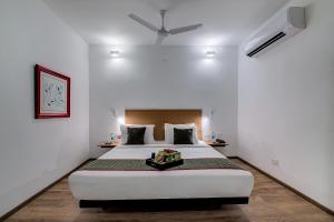 een slaapkamer met een groot wit bed en een plafond bij Townhouse 056 T Nagar Chennai Near AGS Cinemas T Nagar in Chennai