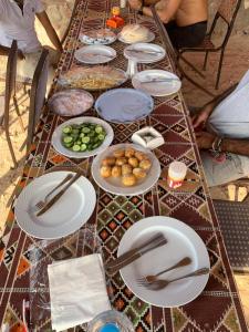 a long table with plates of food on it at Blend in Nature Camp in Sharm El Sheikh