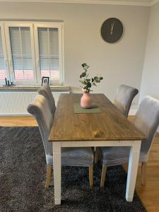 - une table à manger avec des chaises et un vase dans l'établissement Ferien Haus Im Alten-Land Die Lühe vor der Tür, à Steinkirchen