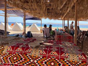 a group of people sitting at a table on the beach at Blend in Nature Camp in Sharm El Sheikh